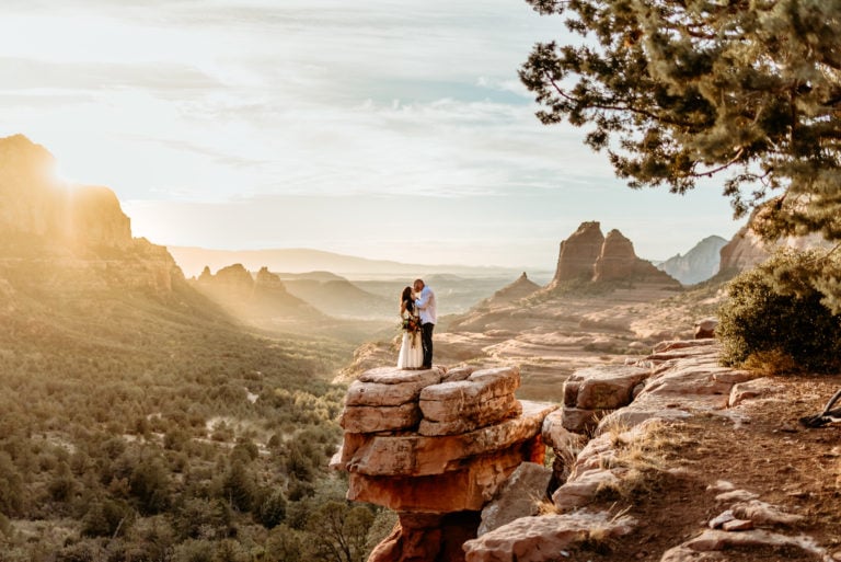 Couple embracing on Merry Go Round Rock overlook during their Sedona, Arizona elopement