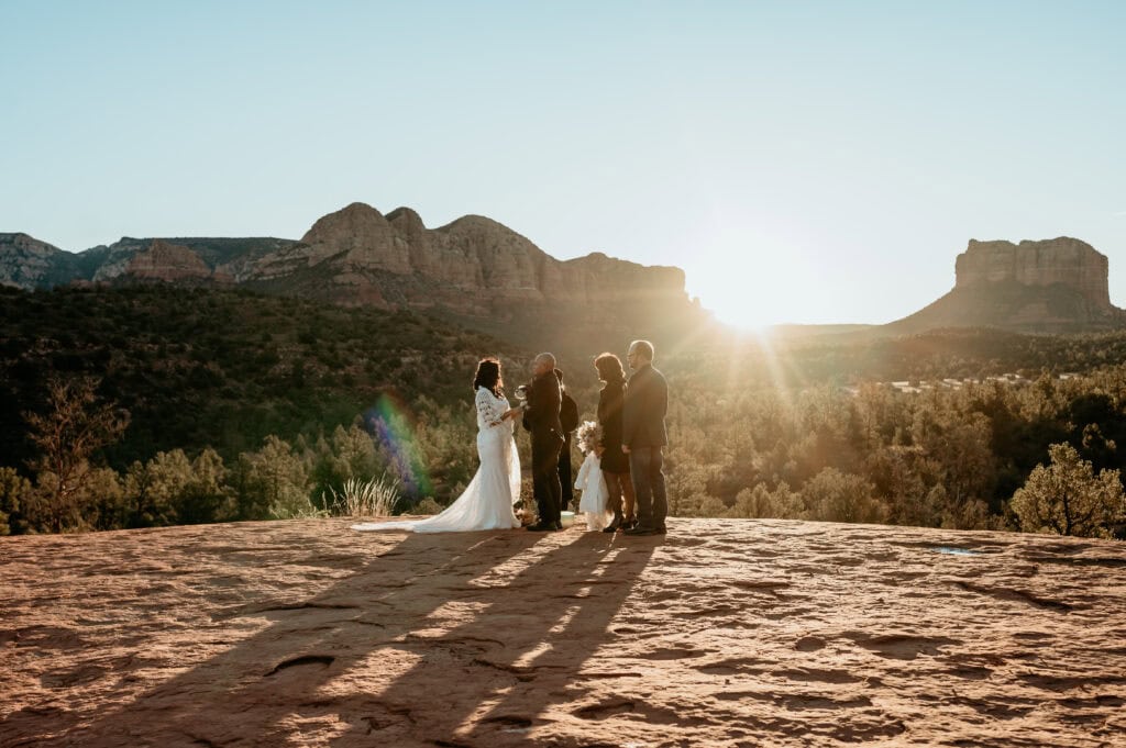 family surrounds bride and groom during their sunrise elopement