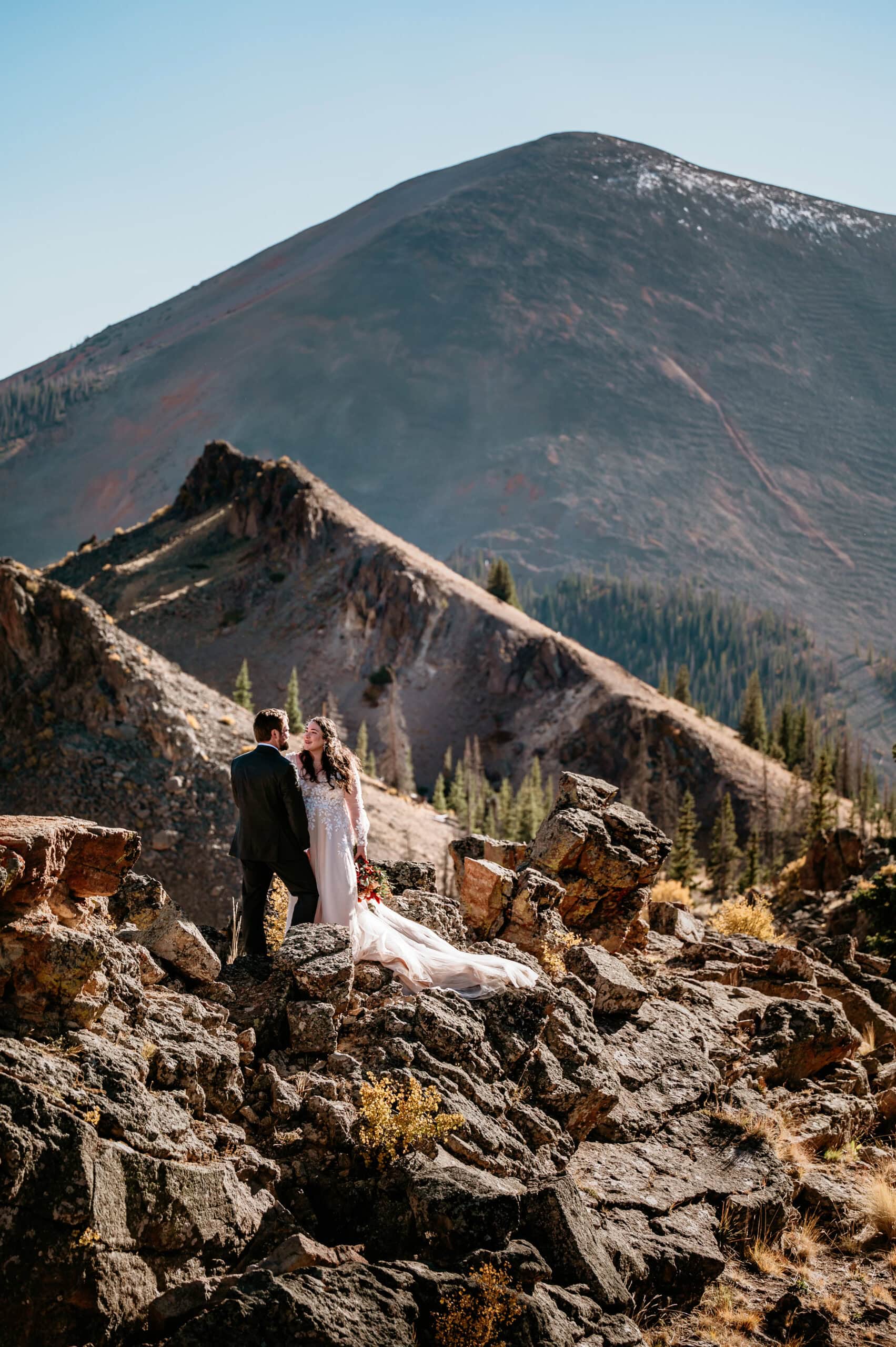 Couple standing above jagged mountain peaks during their San Juan Mountains  Elopement in Colorado