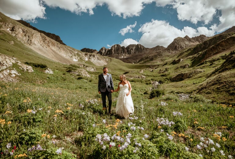 San Juan Mountains elopement with couple walking on a trail through summer wildflowers