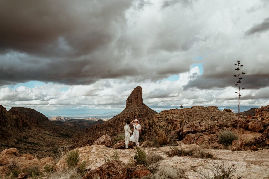 Couple exploring with Weavers Needle behind them for their Arizona elopement by Stratus Photography