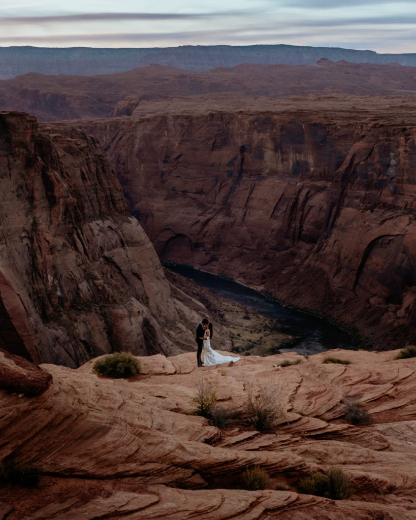 Looking down on the Colorado River and couple on the ledge in Page, Arizona