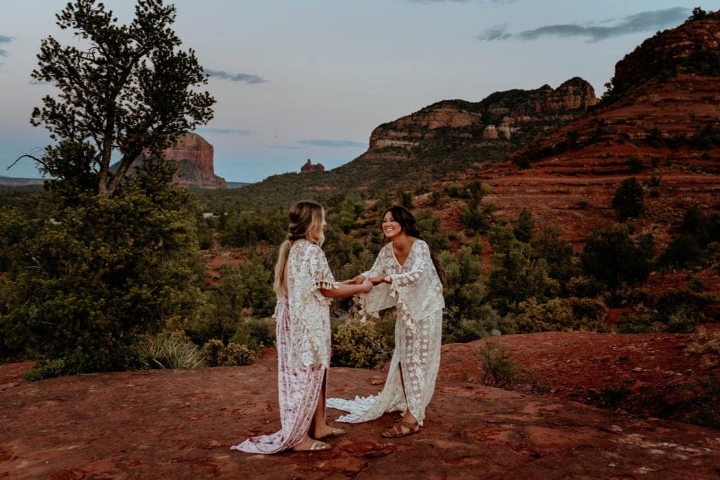 Bride and maid of honor dance and laugh at Sedona ceremony