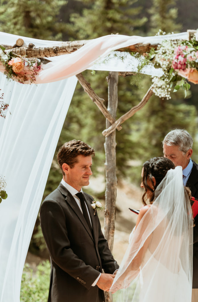 Benton lovingly looks at Liz during their Colorado mountain wedding