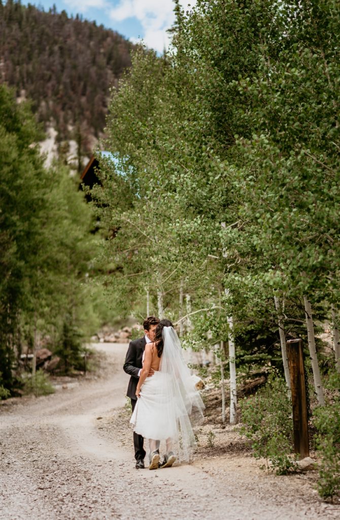 Bride on her tippy toes in her sneakers for a kiss