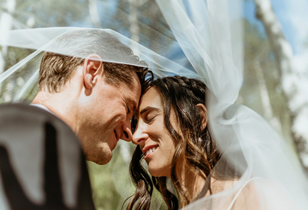 Romantic moment with bride and groom under her veil