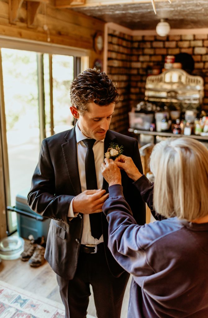 Groom's mom helping pin groom's boutonniere
