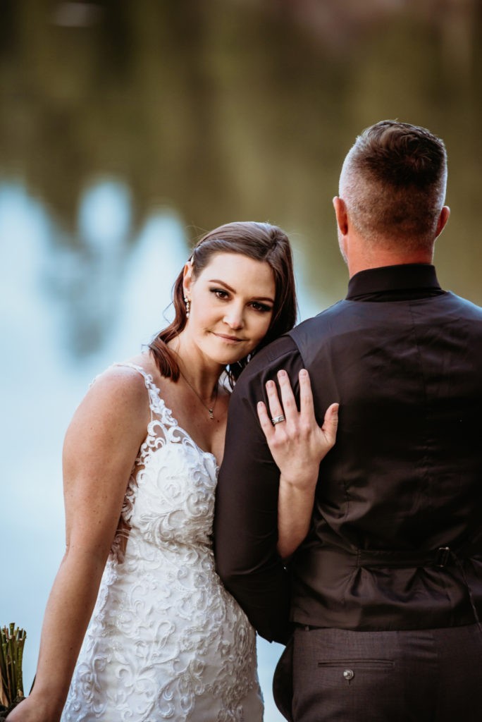 Bride peaking over her new husband's shoulder
