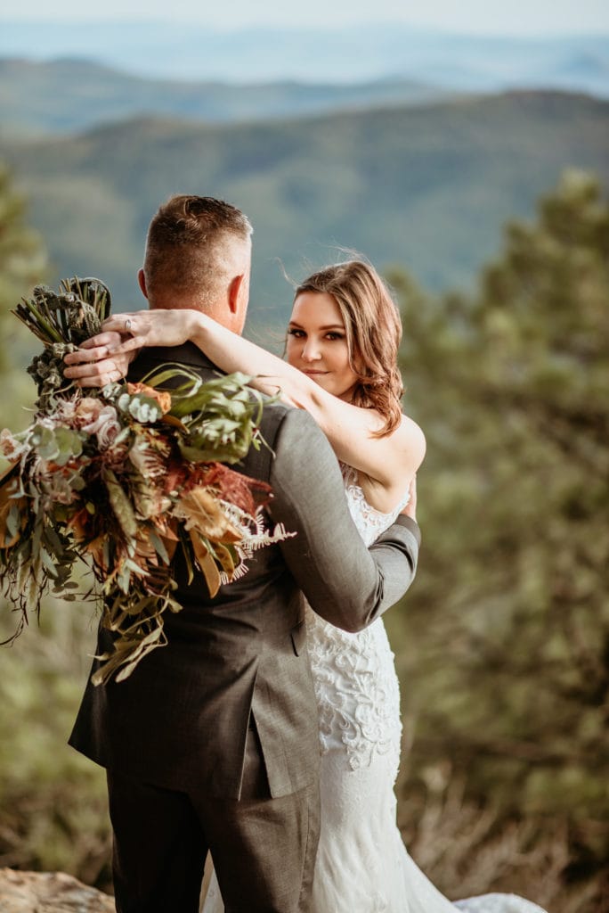 Stunning wildflower bouquet draped over groom's back during northern Arizona elopement