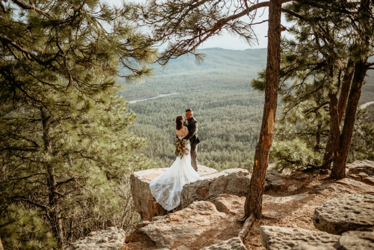 Beautiful elopement couple embracing framed by pine trees in northern Arizona