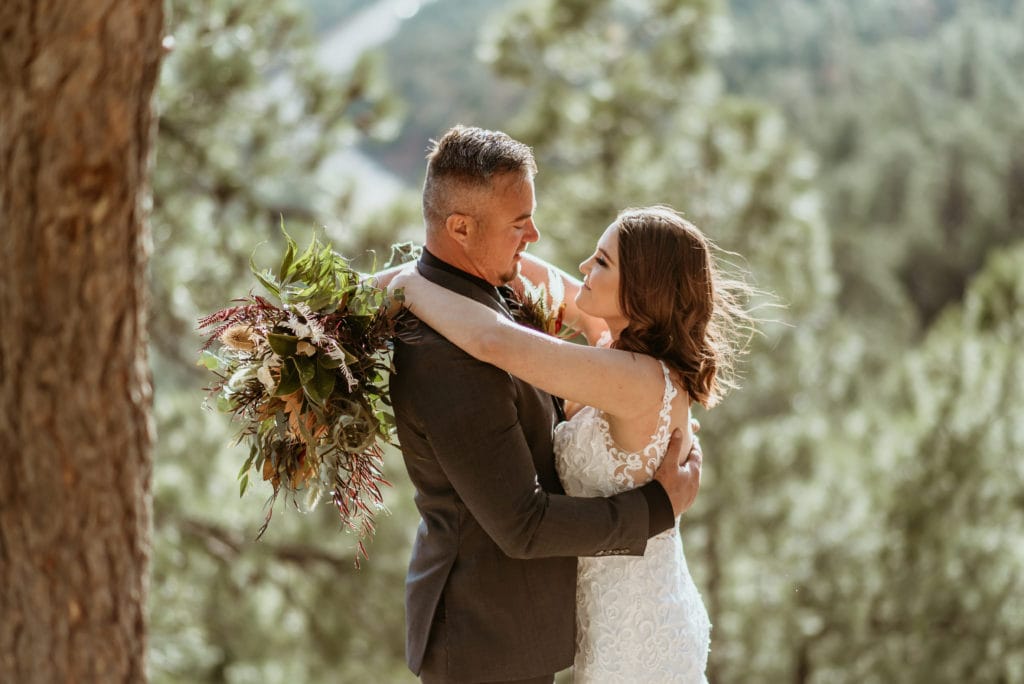 Bride looking up into her husband's eyes during their Mogollon Rim Elopement with gorgeous boho boquet