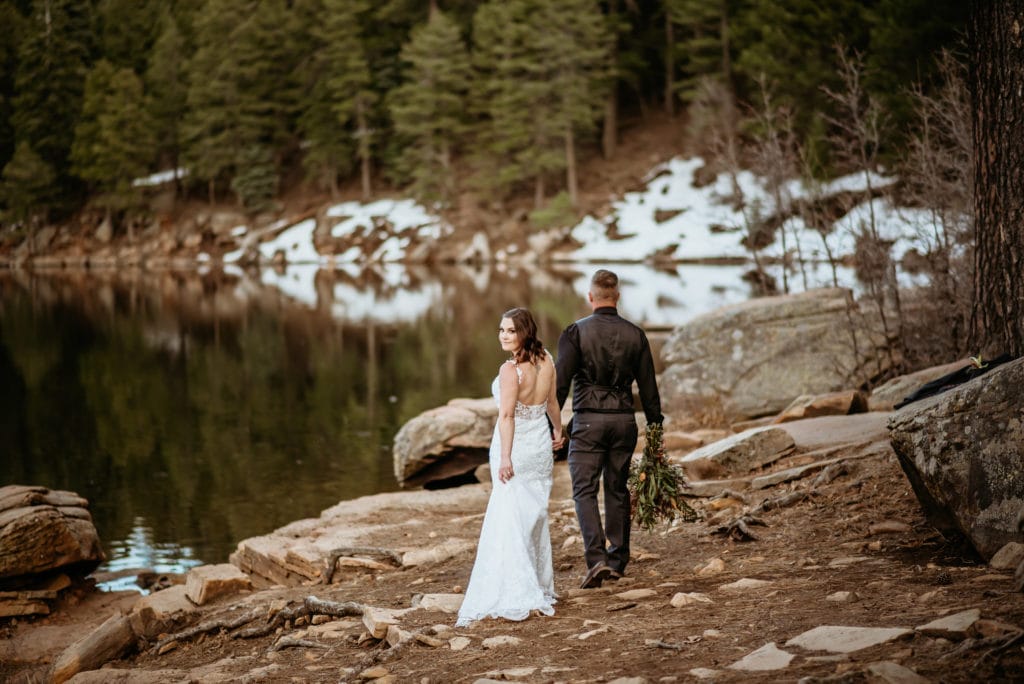 Bride looking back over her shoulder as she is lead by her husband
