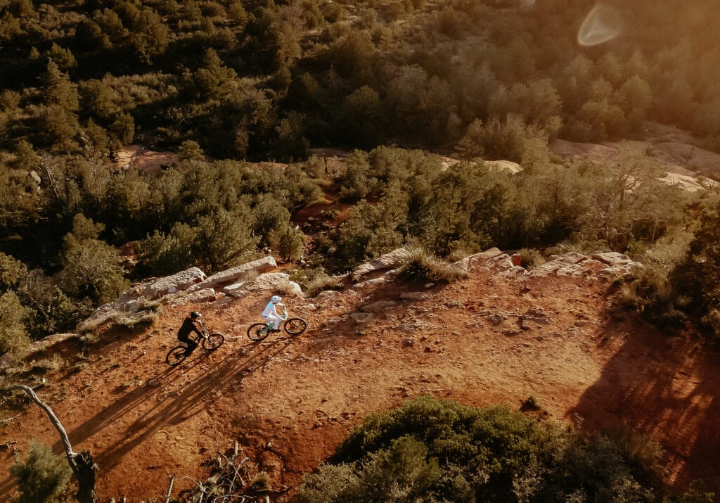 Couple riding bikes on the red rock cliffs of Sedona