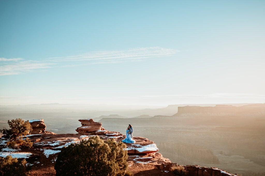 couple standing at the edge of the canyon embracing during their Moab elopement at Deadhorse Point