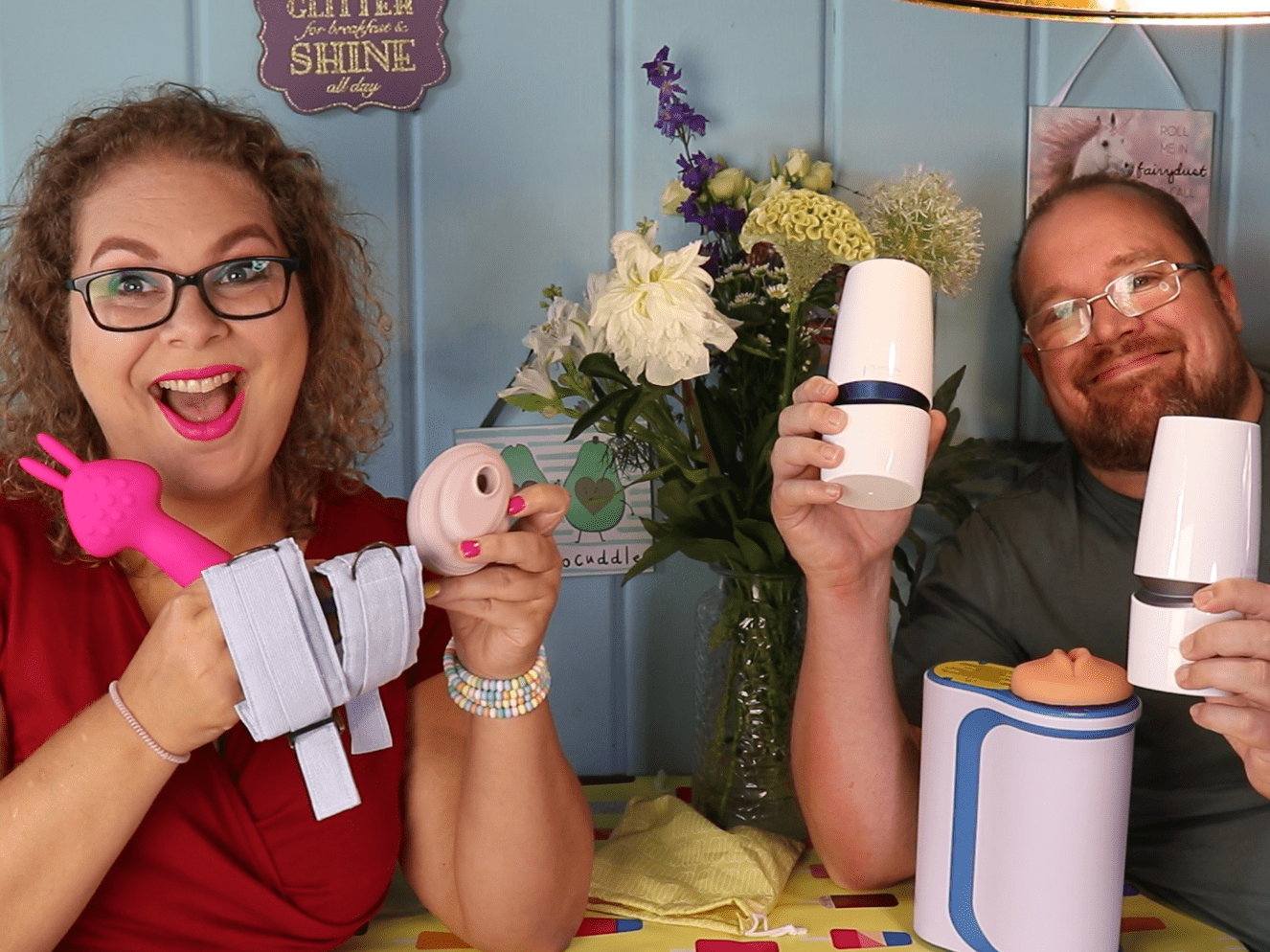 Tess en Jay zitten weer aan de keukentafel en ze houden de toys vast waar ze het over hebben in de video. Ze kijken allebei heel blij.