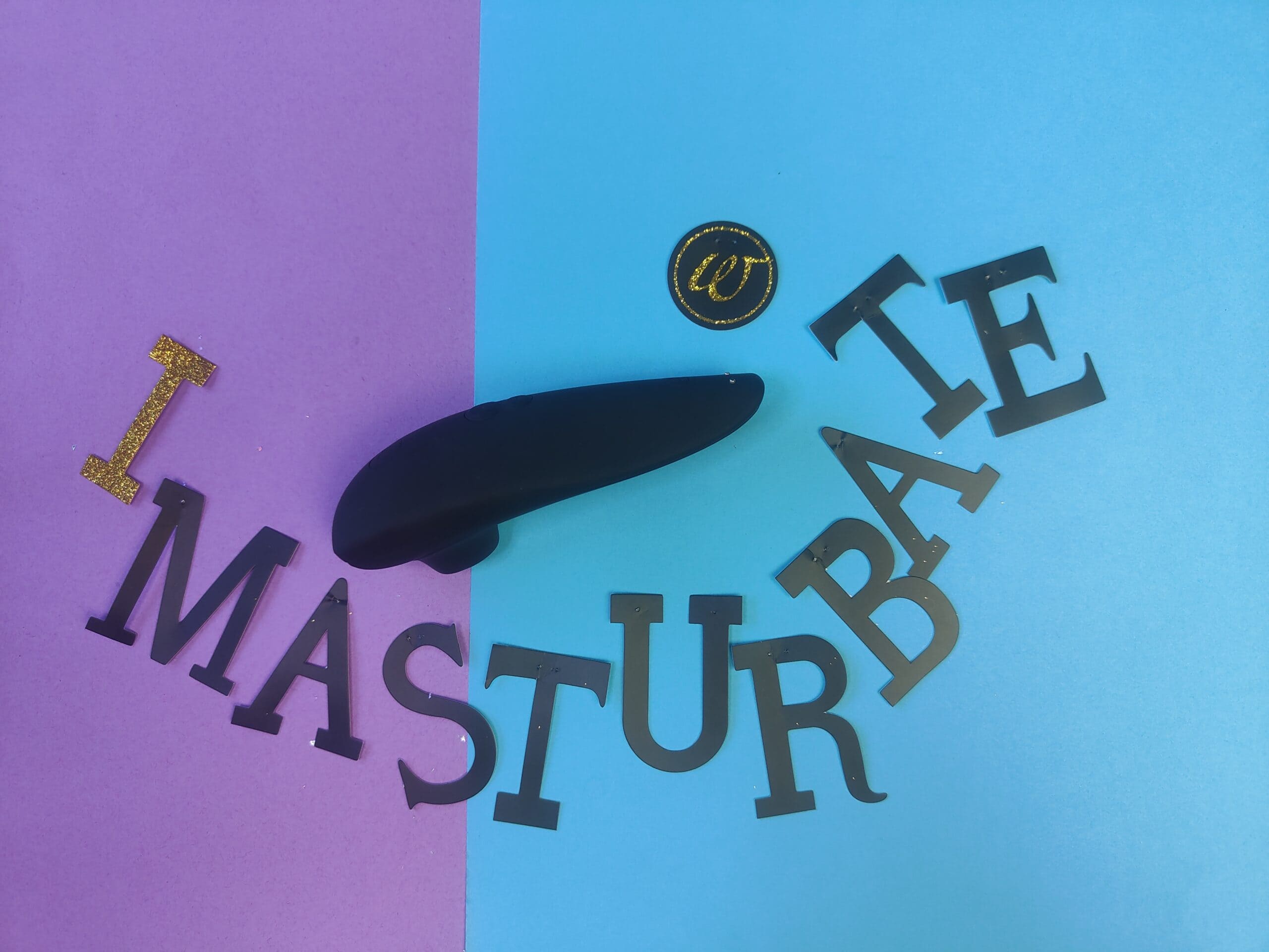 De Womanizer Classic 2 op een paars blauw ondergrondje met de letters I MASTURBATE er omheen.