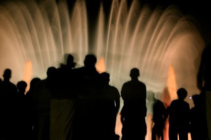 Silhouette of a crowd of people watching a light show.