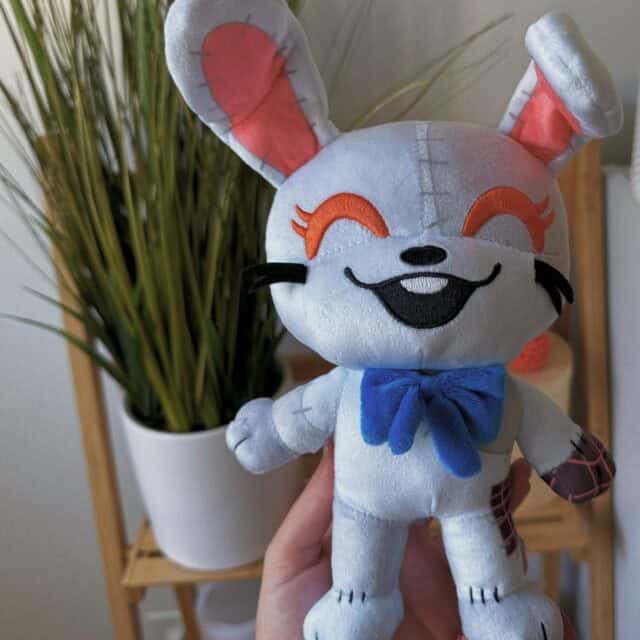 "9-inch Youtooz Five Nights at Freddy's Vanny Chibi plush with grey patchwork design, dark blue bow, and red eyes."