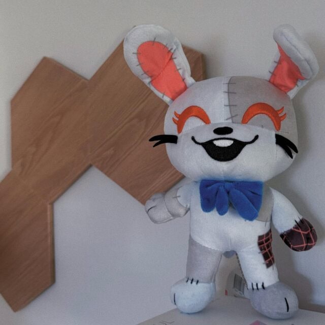 "9-inch Youtooz Five Nights at Freddy's Vanny Chibi Plush with grey patchwork, bright red eyes, and blue bow."