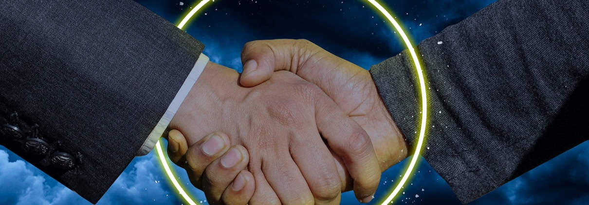 Foto van twee handschuddende armen uit een colbert.