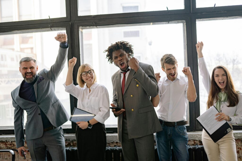 Five employees showing excitement because they are happy with the company culture.