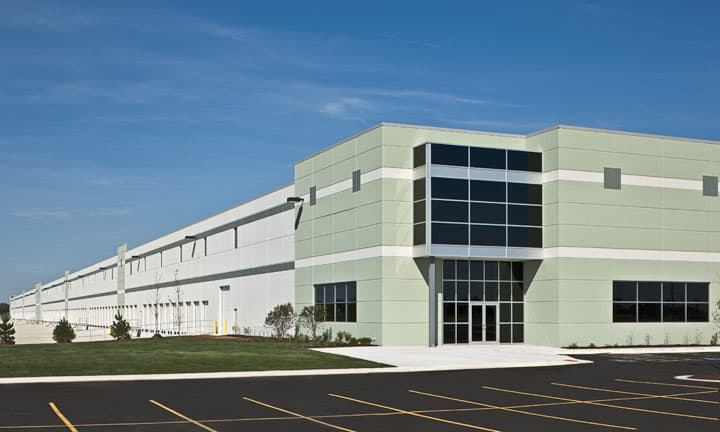 The modern exterior of the Heartland Corporate Center stretches into the distance, surrounded by a clean parking lot.