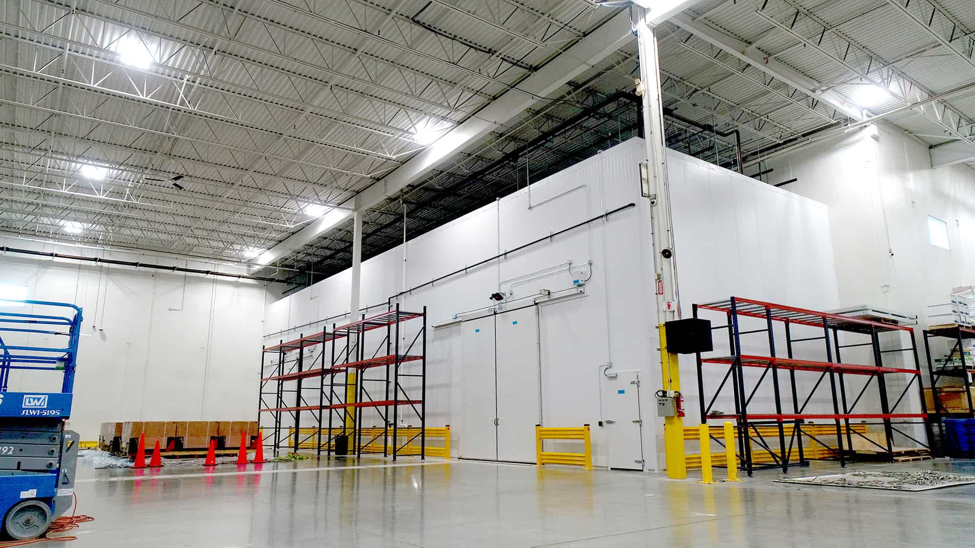 Metal shelves sit against a large white windowless room inside a well-lit warehouse. Keeley Construction made interior improvements, including pharmacological freezers and coolers.