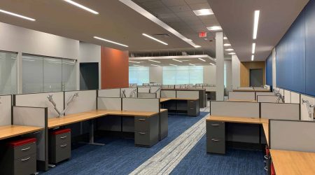 A long view of a room containing modernized cubicles and workspaces.