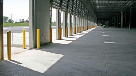 Light and shadow play on the concrete floor of the Heartland Corporate Center from open bay doors in the shipping and deliverables area.