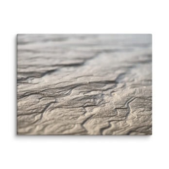 Primer plano de patrones de arena ondulada, con sombras y reflejos suaves. La textura muestra líneas y curvas naturales, lo que sugiere un paisaje de playa o desierto sereno. Perfecto para quienes aprecian el "Lienzo surcos arena mojada" de Volcanica Productions, que captura la esencia de Paisajes Canarios con asombrosos detalles.