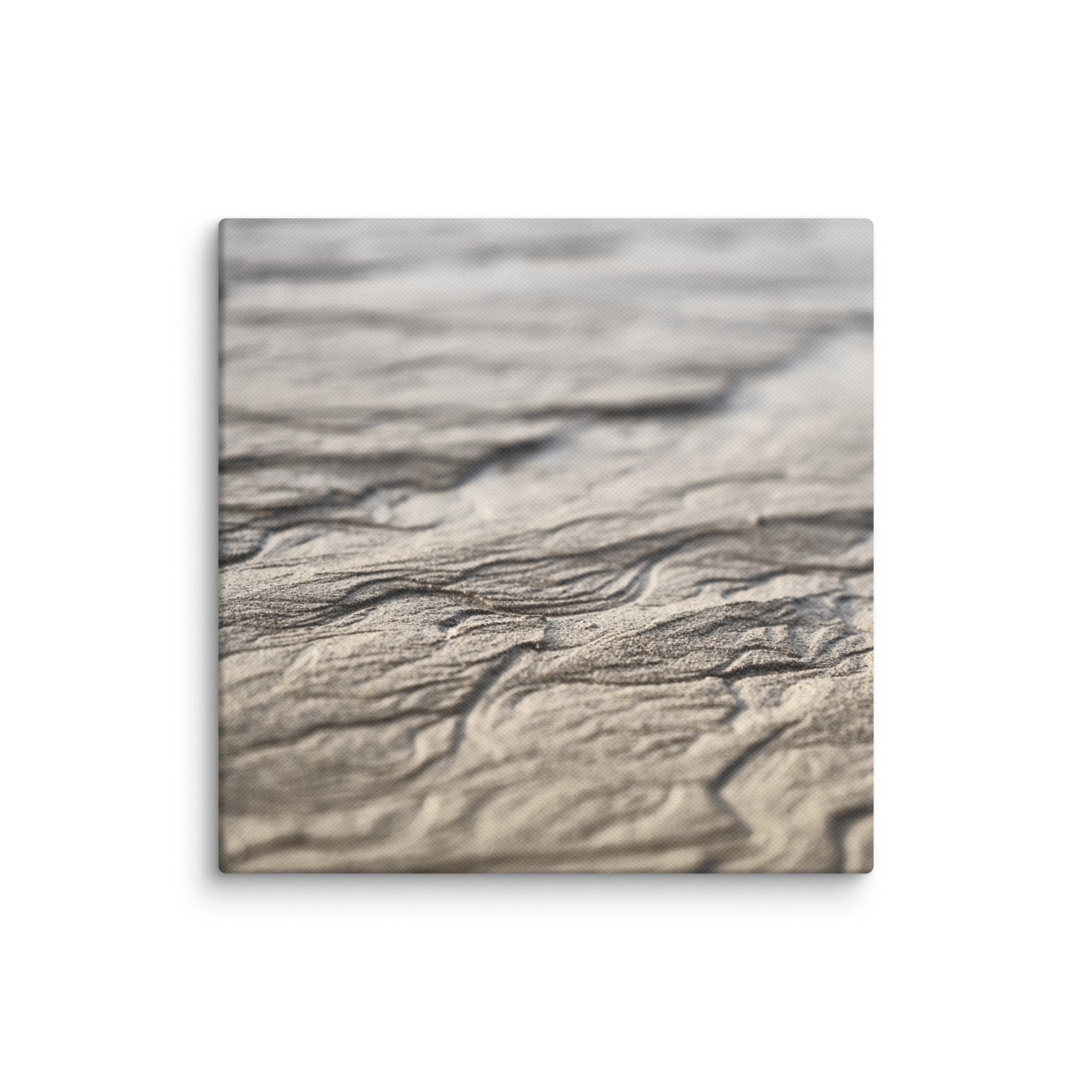 Primer plano de patrones de arena ondulada en la "Lienzo surcos arena mojada", que se asemejan a olas naturales en tonos neutros. La textura es detallada y captura líneas suaves y curvas bajo una luz suave. Esta imagen serena y abstracta evoca la belleza volcánica que a menudo se asocia con los paisajes únicos de La Palma.