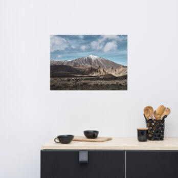 En primer plano se encuentra un mostrador de cocina adornado con tazas negras y un portautensilios, mientras que en la pared blanca cuelga un póster del Teide de Volcanica Productions, que representa una montaña cubierta de nieve bajo un cielo azul, que recuerda las impresionantes vistas de La Palma.