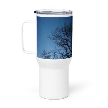 El "Termo con asa ramas fondo azul" es una taza de viaje blanca con tapa transparente y adornada con una imagen de ramas de árboles desnudos contra un cielo azul claro, que evoca los tranquilos paisajes de La Palma. Está disponible en nuestra Tienda online y es un regalo muy especial.