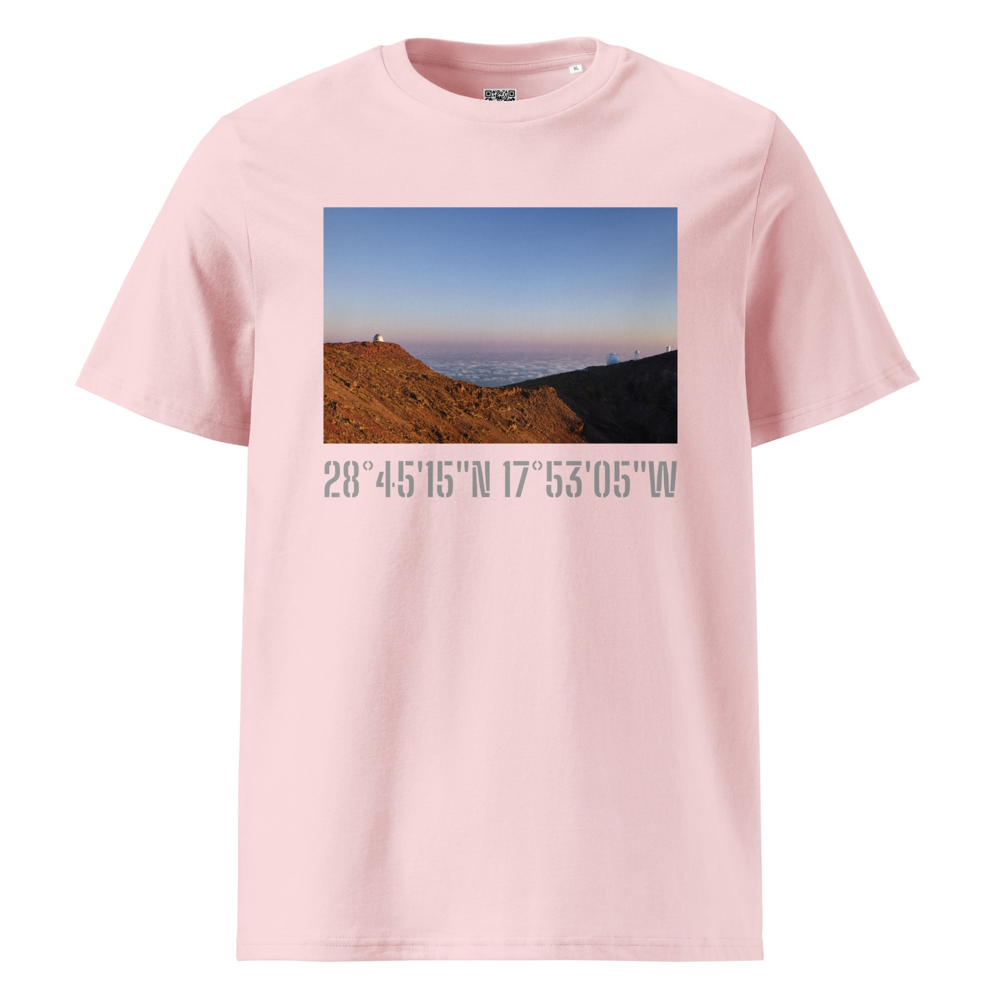 La camiseta unisex Telescopios del Roque de los Muchachos de Volcanica Productions es una camiseta rosa que presenta una impresionante fotografía de un paisaje de una montaña con una persona en la cima al atardecer, con "Arte Decorativo" inscrito junto a las coordenadas: 28°45'15"N 17°53'05"W.