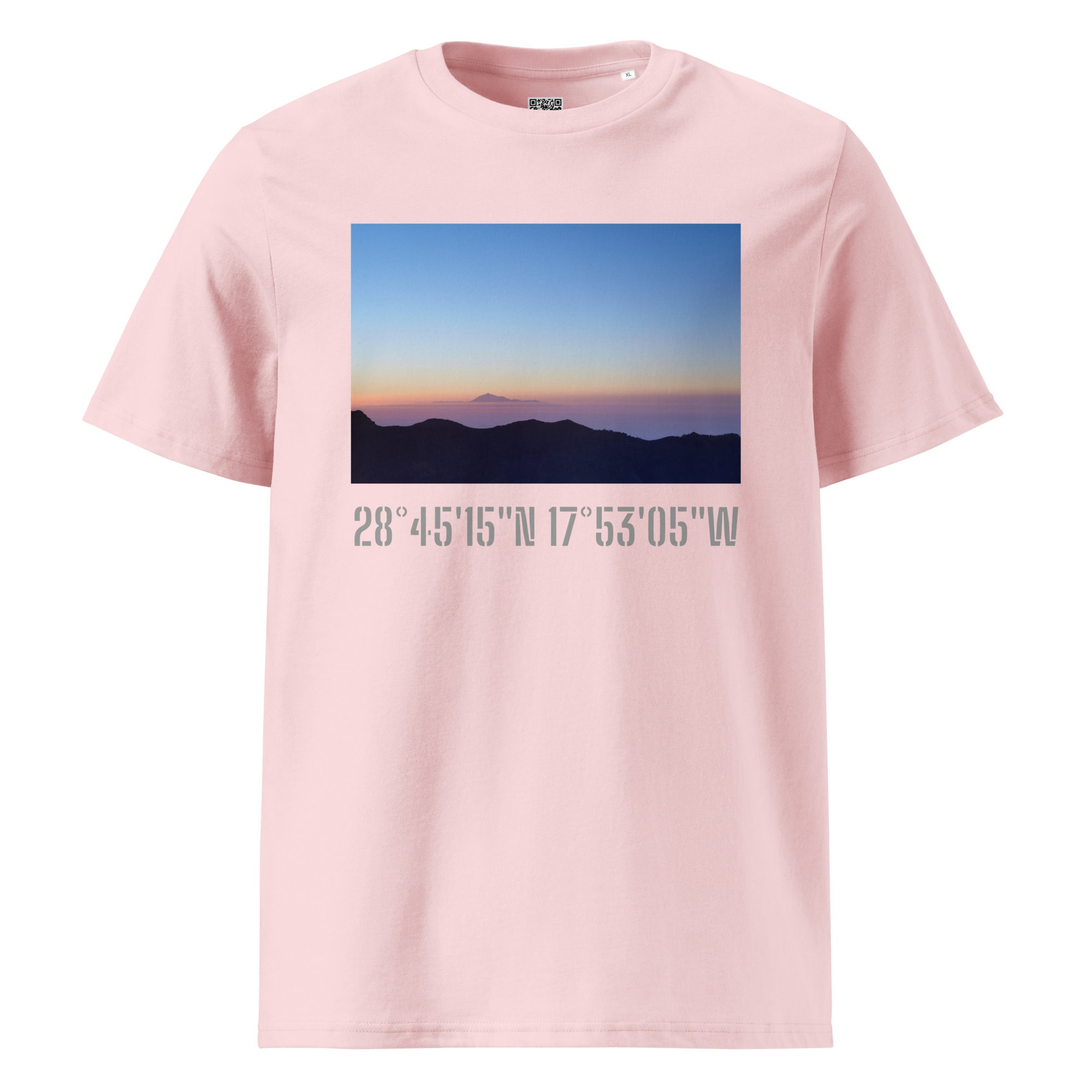 La camiseta unisex "Amanecer desde el Roque de los Muchachos" de Volcanica Productions es una camiseta rosa que muestra un impresionante atardecer o amanecer sobre montañas lejanas. Debajo de la imagen, están impresas las coordenadas geográficas 28°4515N 17°5305W, que resaltan los impresionantes paisajes de La Palma en la serie Paisajes Canarios.