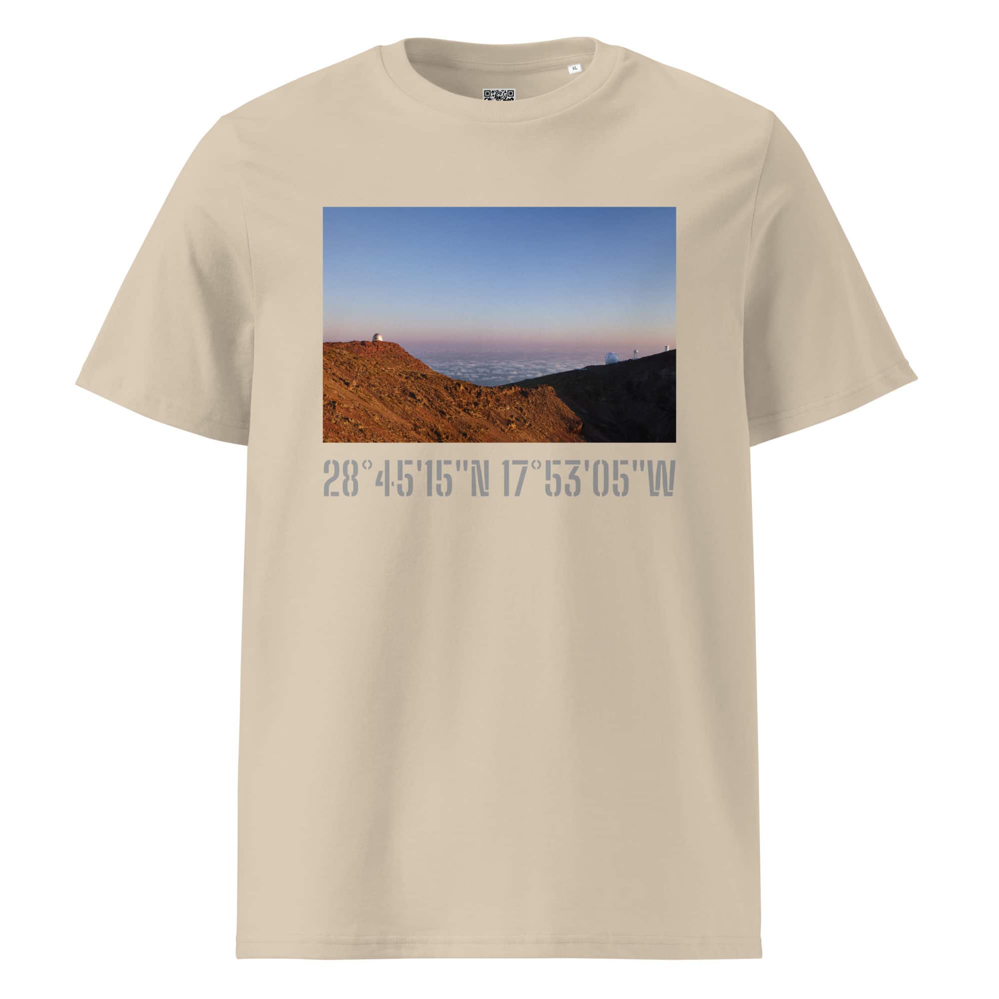 Camiseta unisex Telescopios del Roque de los Muchachos en color beige, con un paisaje montañoso de Paisajes Canarios bajo un cielo azul despejado. Debajo de la imagen, encontrarás las coordenadas: 28° 4515N 17°5305W. Disponible ahora en Tienda Online, cortesía de Volcanica Productions.