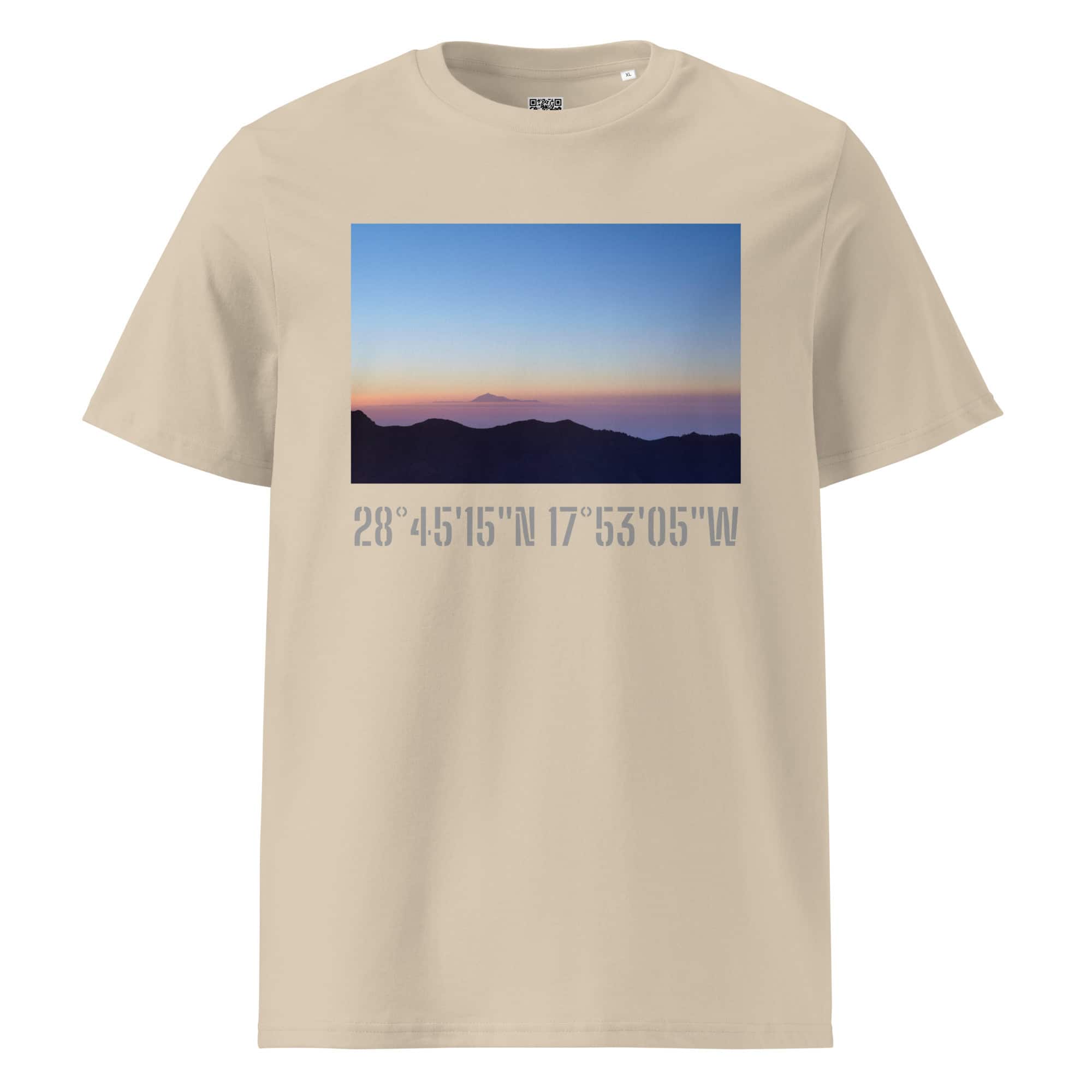 Esta camiseta beige, llamada "Camiseta unisex Amanecer desde el Roque de los Muchachos", presenta un paisaje de montaña al atardecer con el pico de La Palma a lo lejos y muestra elegantemente las coordenadas 28°4515N 17°5305W debajo de la imagen. Sirve como homenaje a Paisajes Canarios de Volcanica Productions.