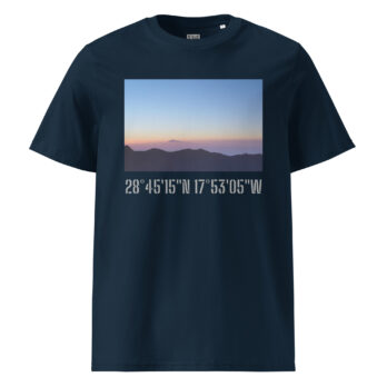La camiseta unisex Amanecer desde el Roque de los Muchachos es una camiseta azul marino que presenta una fotografía panorámica de un atardecer o amanecer sobre las lejanas montañas de La Palma, con un cielo naranja y violeta como fondo. Debajo de esta cautivadora imagen, las coordenadas 28°4515'N 17°5305'W están impresas en negrita en blanco.