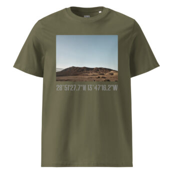 La camiseta unisex Los Ajaches en color verde oliva muestra una imagen de paisaje de una montaña bajo un cielo azul claro, capturando la esencia de Paisajes Canarios. Las coordenadas en gris claro, 28°51’27.7”N 13°47’16.2”W, están impresas debajo del diseño. Esta obra de arte para vestir es de fácil acceso a través de Tienda Online.