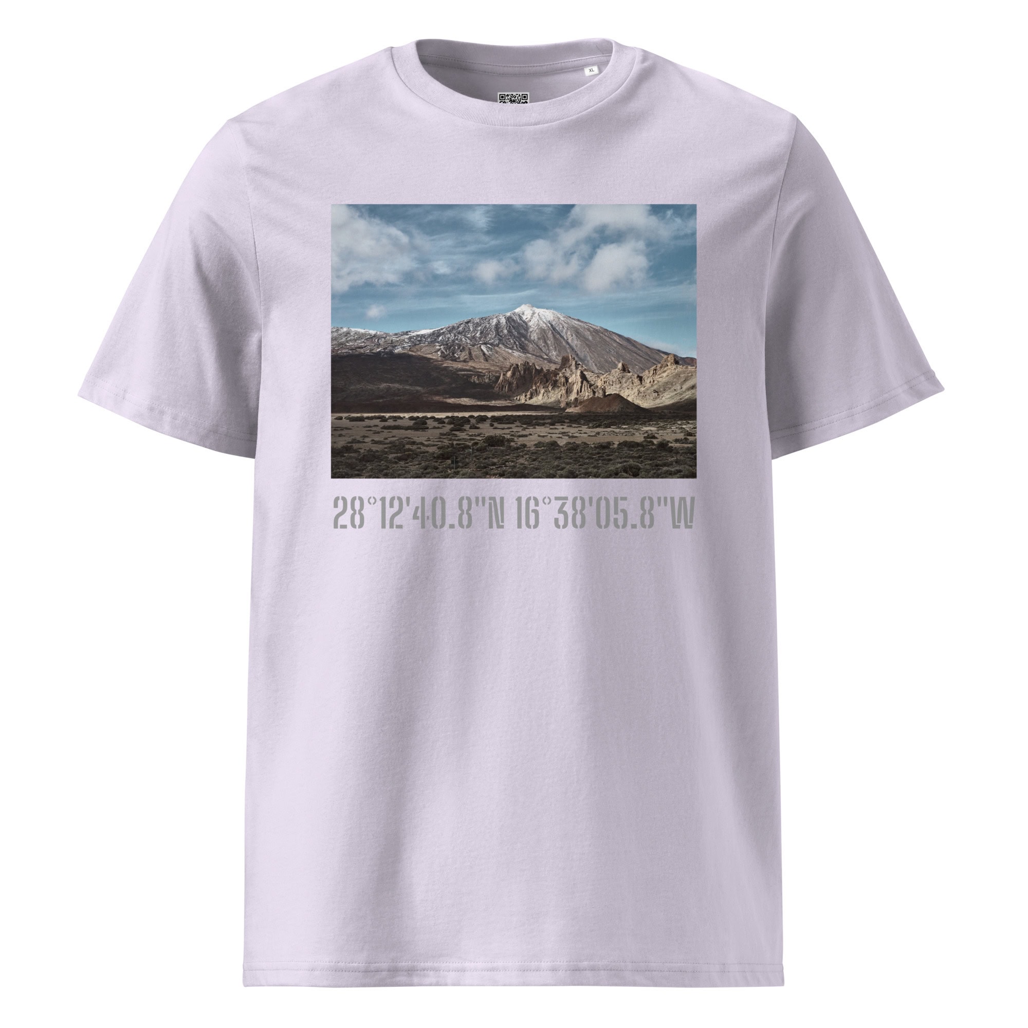La camiseta unisex Teide Nevado de Volcanica Productions presenta una representación de una cordillera con formaciones rocosas bajo un cielo azul. Debajo de esta imagen artística se muestran las coordenadas impresas 28°1240.8N 16°3805.8W. Esta pieza exclusiva está disponible en Tienda Online para los amantes del Arte Decorativo.