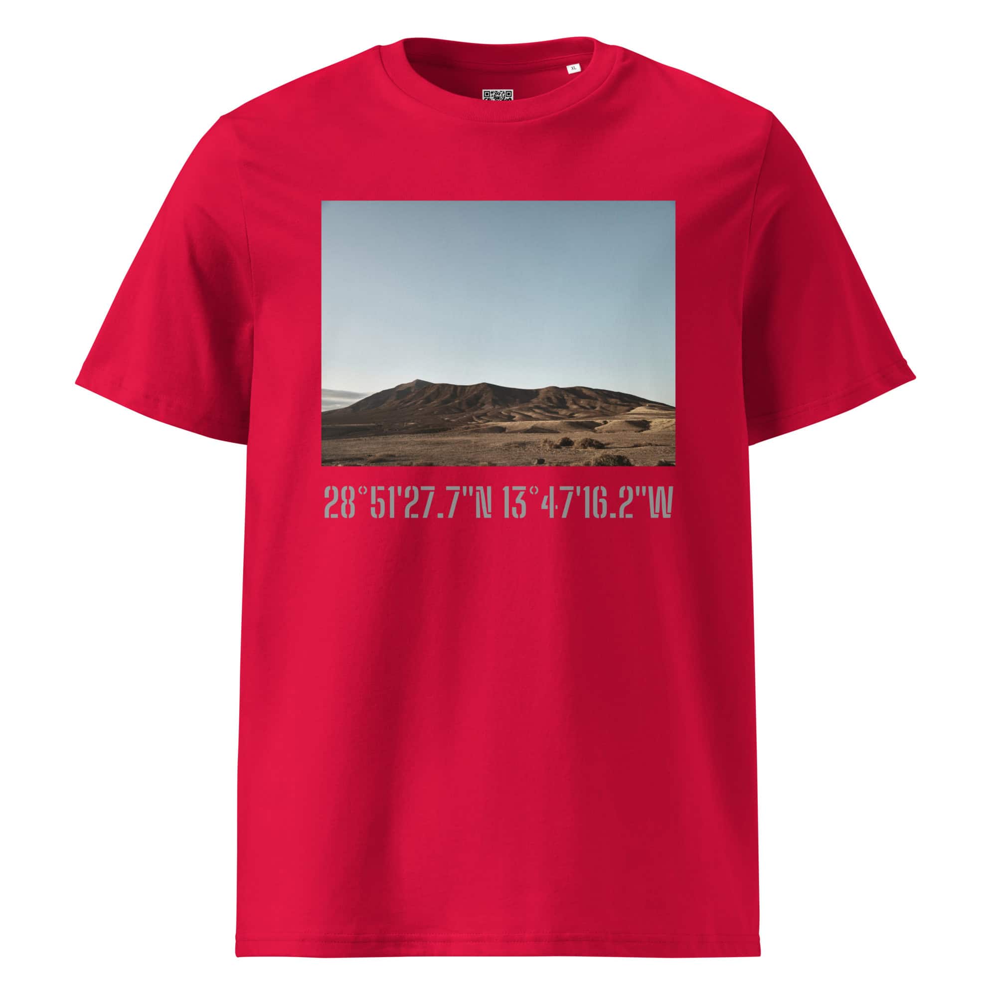 Presentamos la "Camiseta unisex Los Ajaches": una camiseta roja que muestra una impresionante fotografía de un paisaje desértico con colinas bajo un cielo azul claro. Las coordenadas 28°51'27.7"N 13°47'16.2"W, inspiradas en la cautivadora belleza de La Palma, están elegantemente impresas debajo de la imagen. Este artículo exclusivo está disponible solo en la Tienda Online de Volcanica Productions.