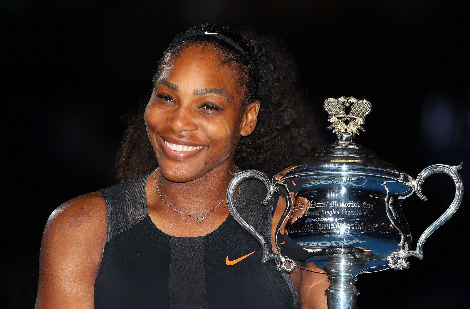 Serena Williams On The Tennis Court, A Symbol Of Success And Wealth.