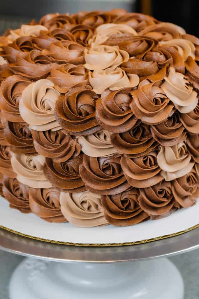 image of chocolate buttercream cake decorated with buttercream rosettes