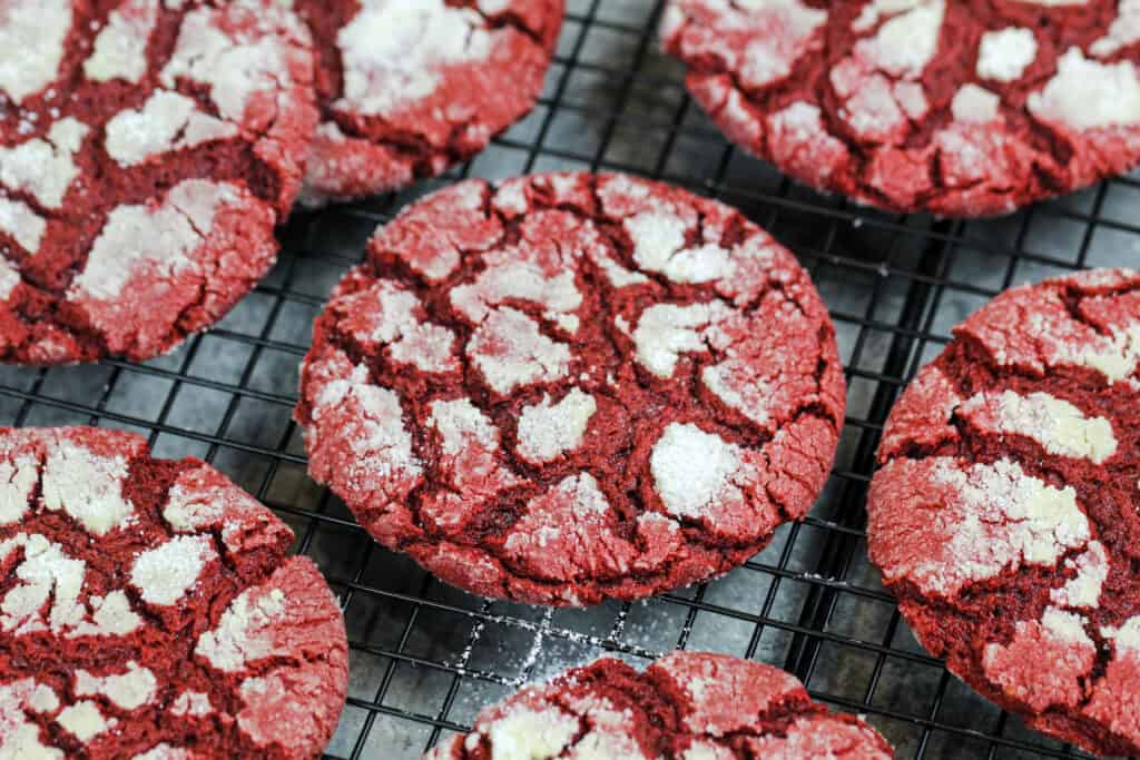image of red velvet crinkle cookies made from scratch cooling on a wire rack
