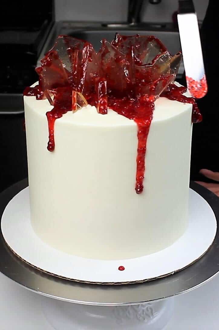 photo of topping this shattered glass cake with edible strawberry jam blood
