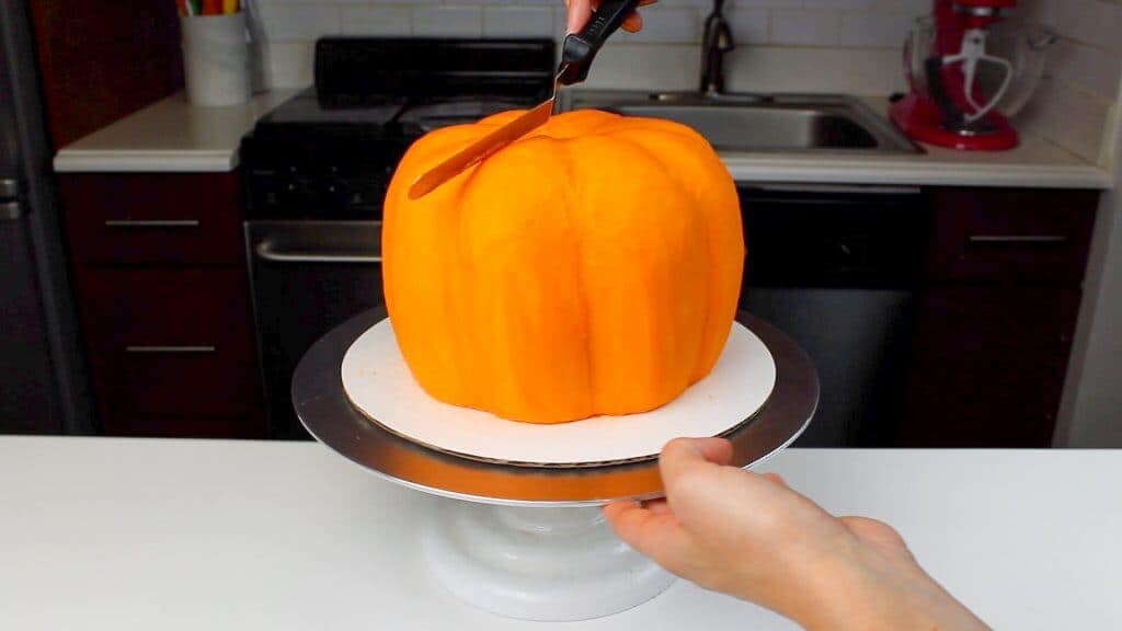 image of smoothing buttercream onto a pumpkin shaped cake