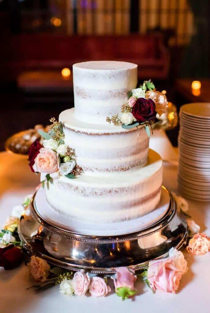 photo of semi naked wedding cake with fresh flowers