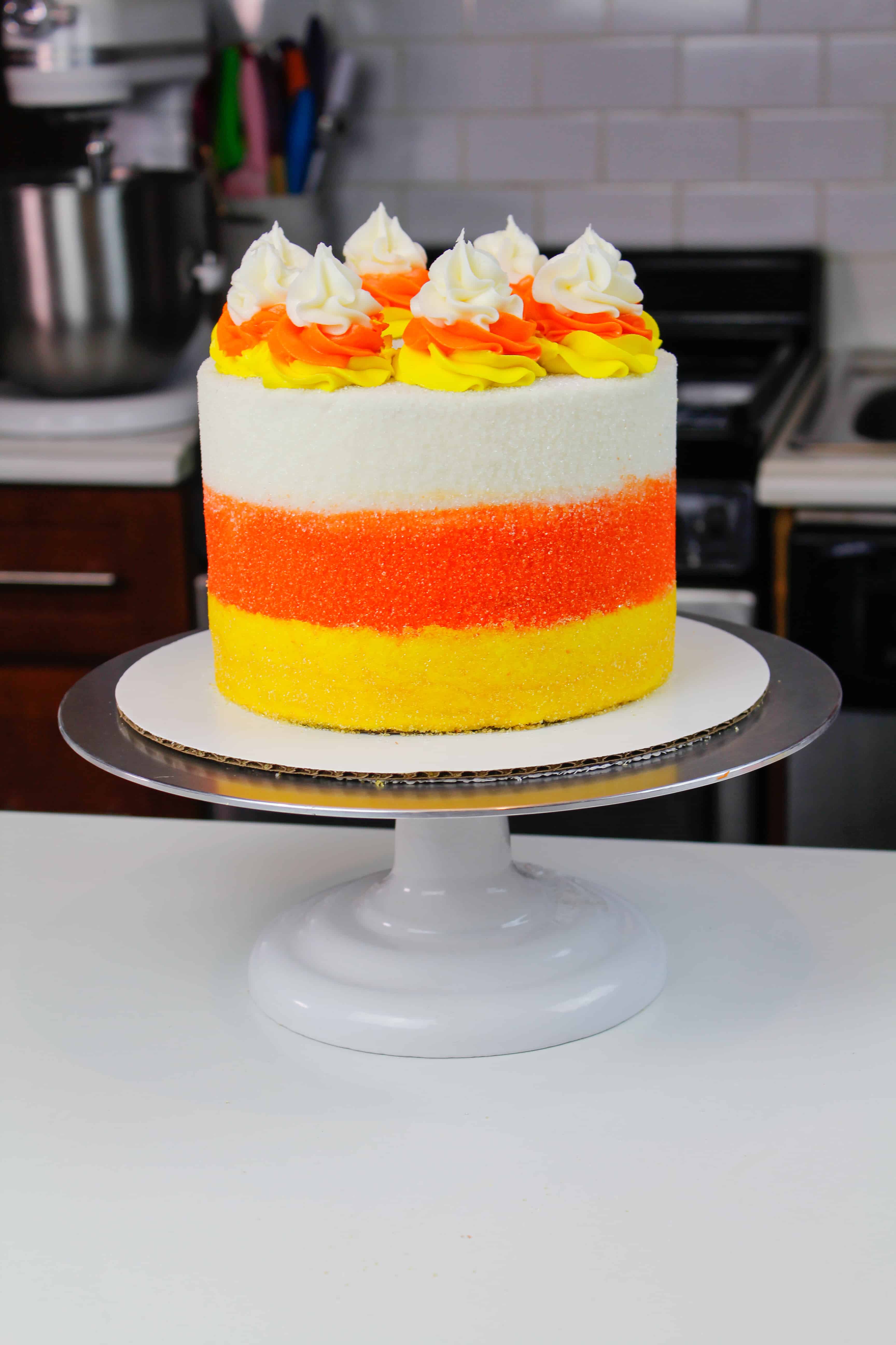 image of candy corn cake, frosted with yellow, orange, and white marshmallow buttercream swirls