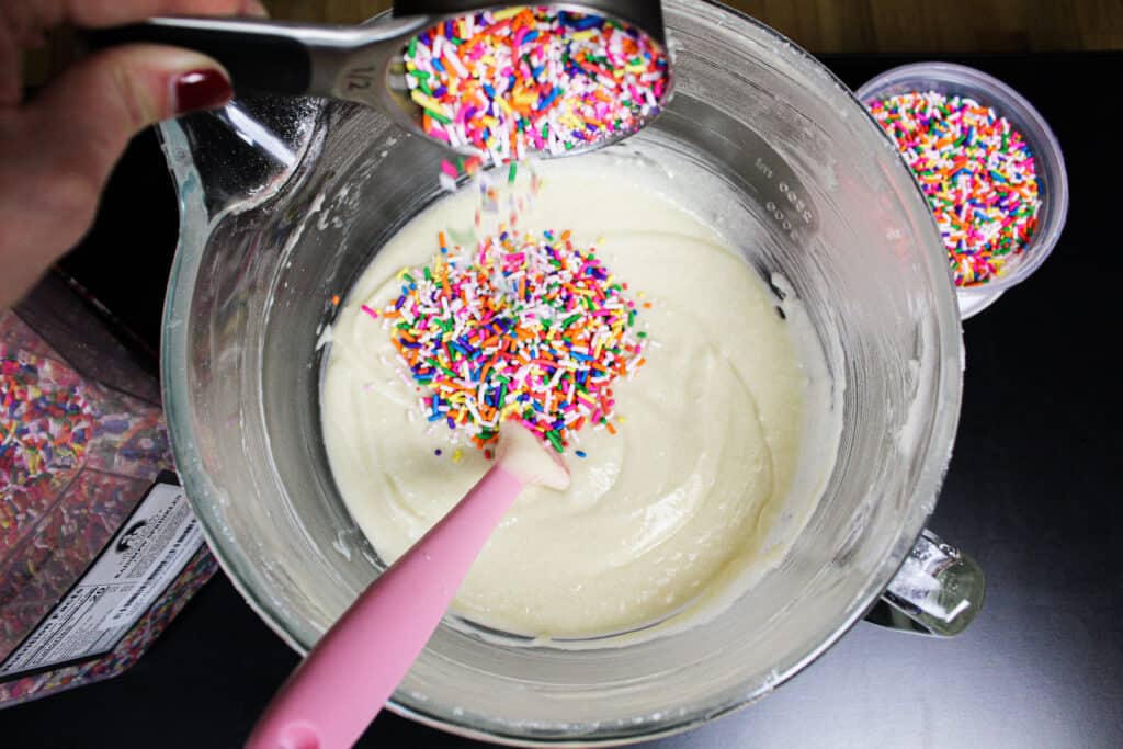image of adding the right type of rainbow sprinkles into funfetti cake batter
