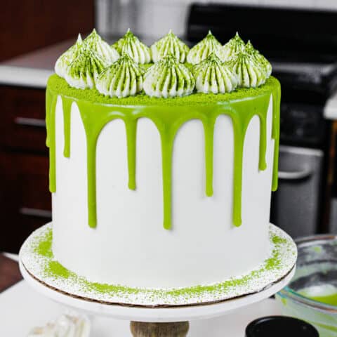 image of a matcha cake with fluffy buttercream frosting dusted in matcha powder